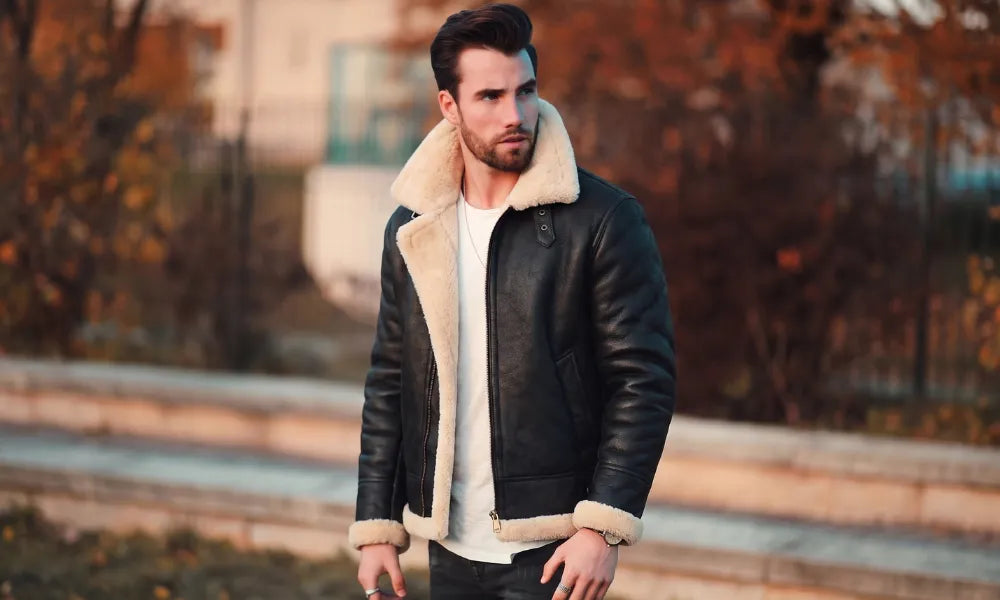 Man wearing a shearling leather jacket over a white shirt outdoors in cool autumn weather.