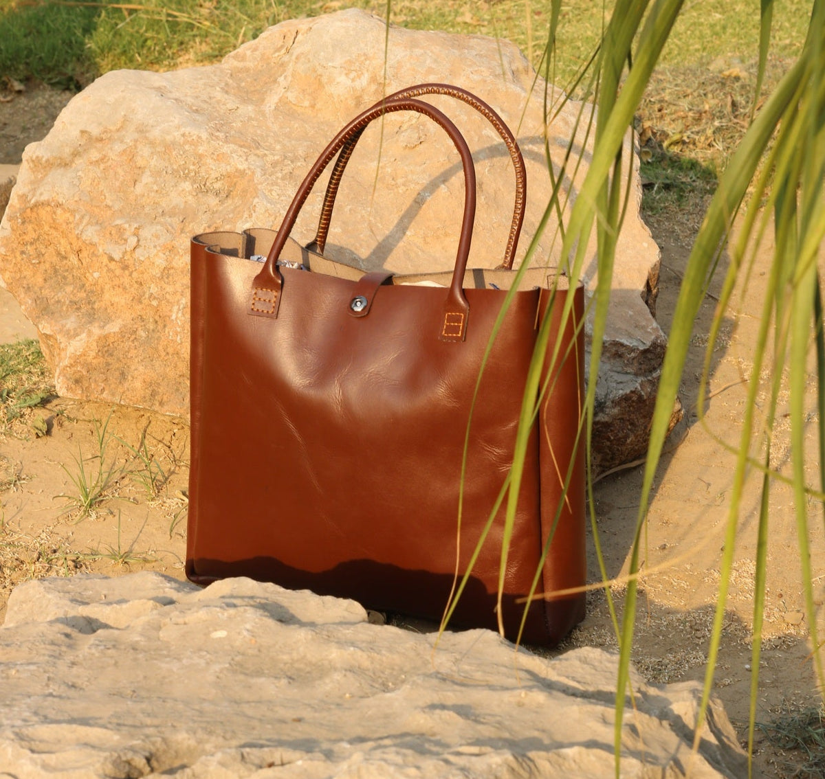 Brown leather handbag on a rock with natural background