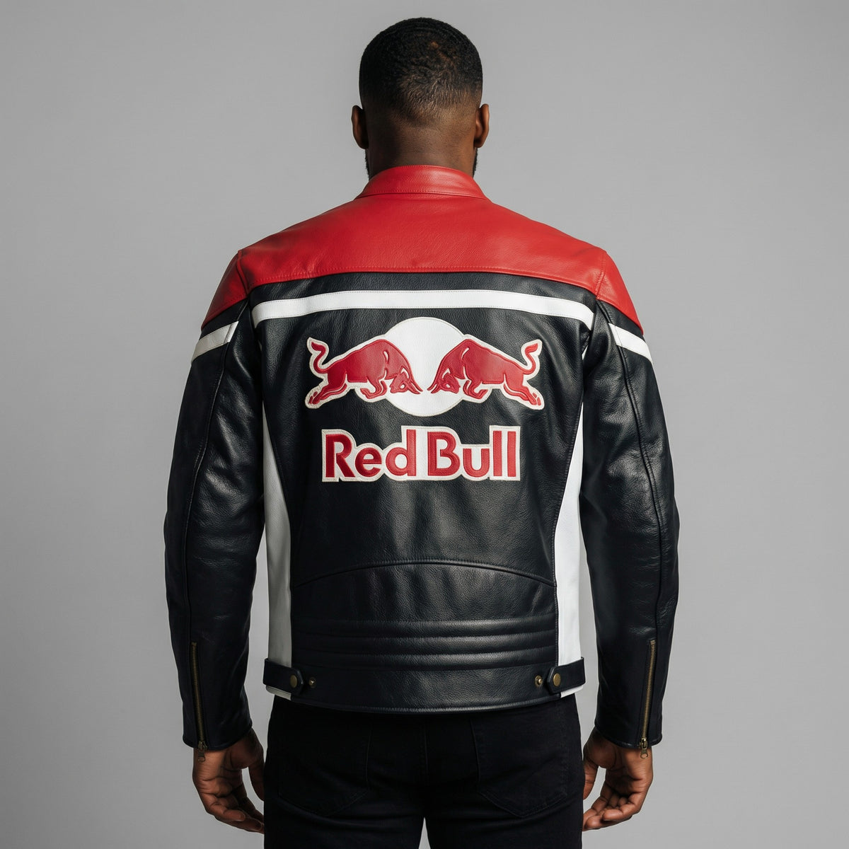 Person wearing a Red Bull branded leather jacket on a gray background