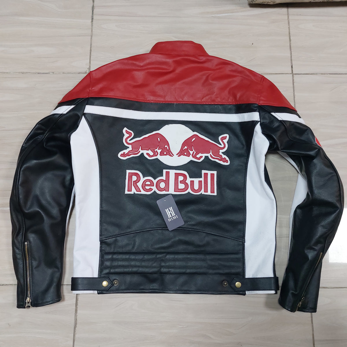 Red Bull branded leather jacket on a tiled floor