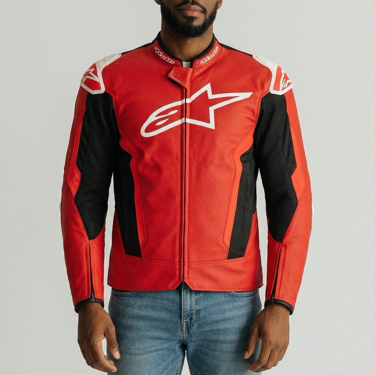 Person wearing a red and black t-gp plus r air jacket with a star logo on a gray background