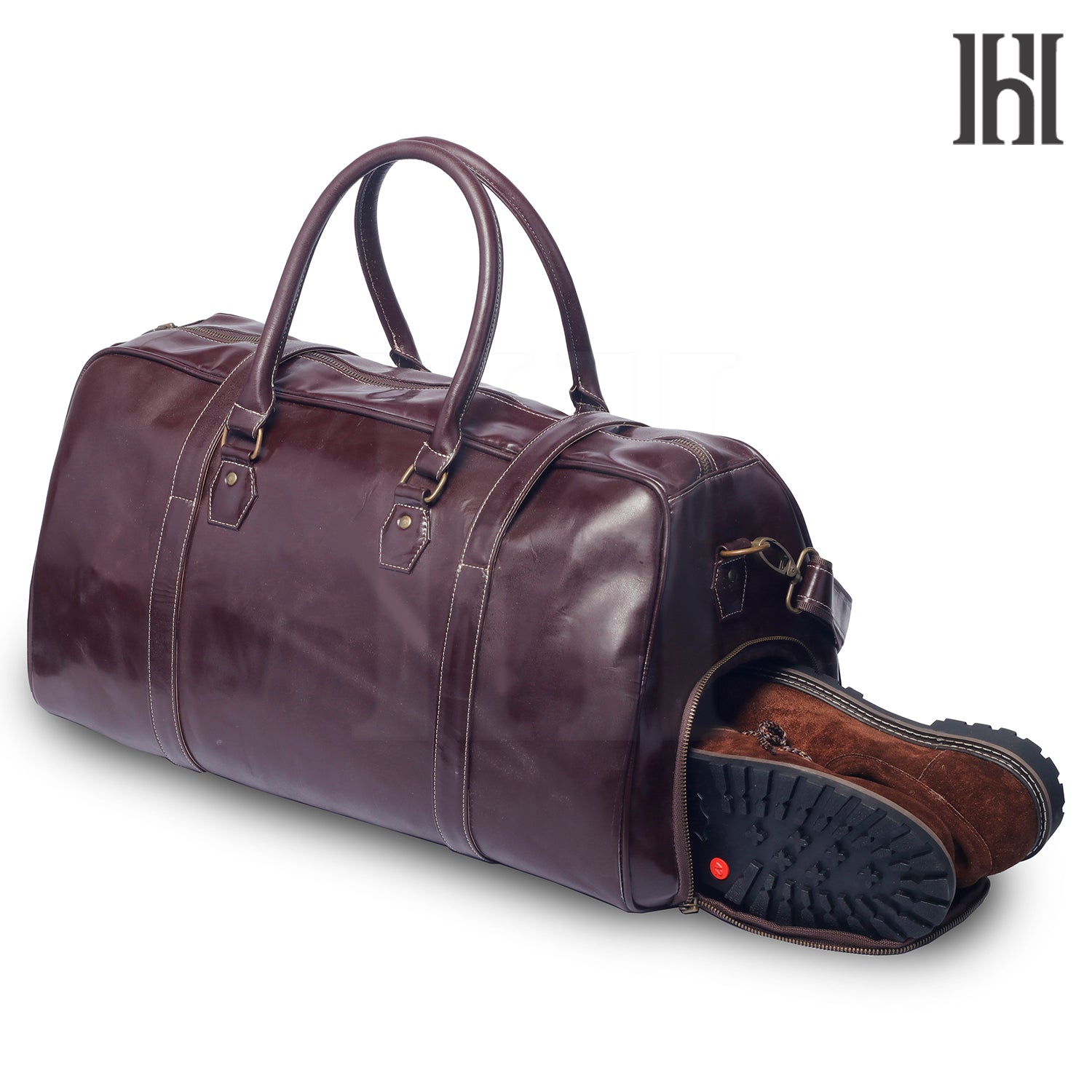 A brown leather duffle bag with a shoe compartment. The bag is shown with a zippered closure and a detachable shoulder strap.
