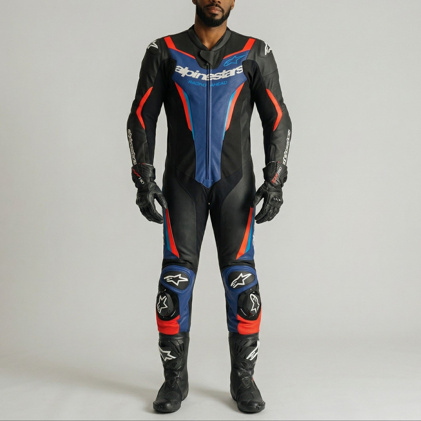 Person wearing a black, blue, and red motorcycle suit with visible branding on a gray background