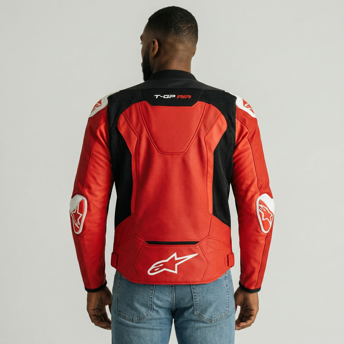 Person wearing a red and black t-gp plus r air motorcycle jacket with visible branding on a gray background