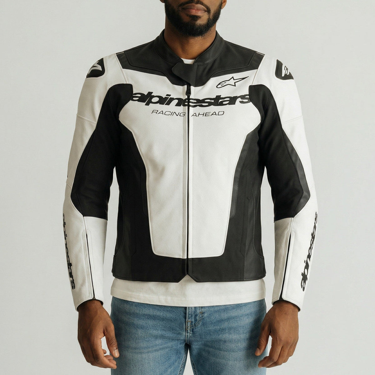 Man wearing a black and white Alpinestars GP Force jacket on a gray background